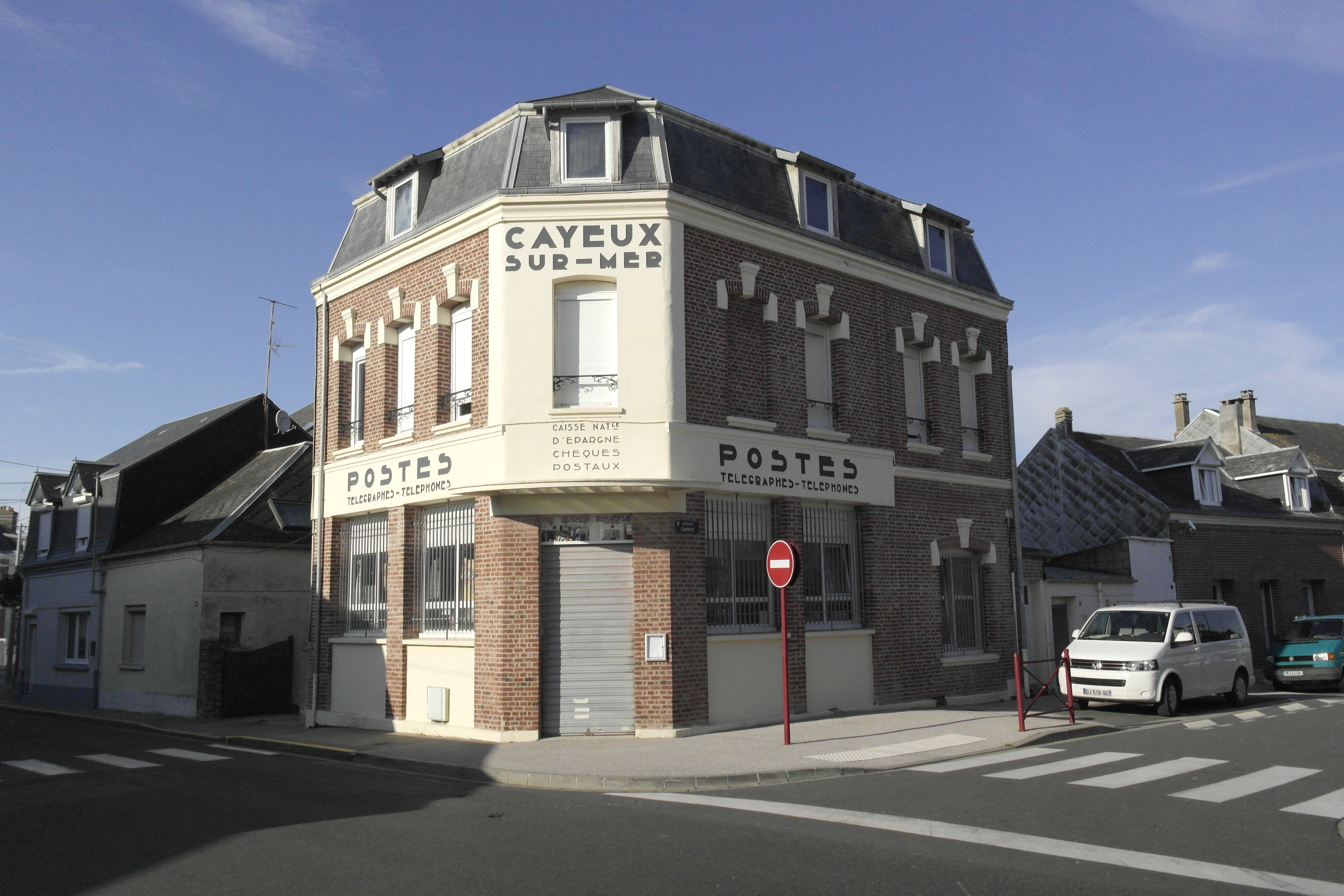 maison d'angle en brique, avec des anciennes typographies en enseigne, ce sont les anciennes PTT