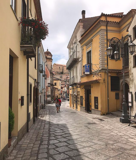 rue de Maratea bordées de maisons jaunes, on voit un clocher au loin