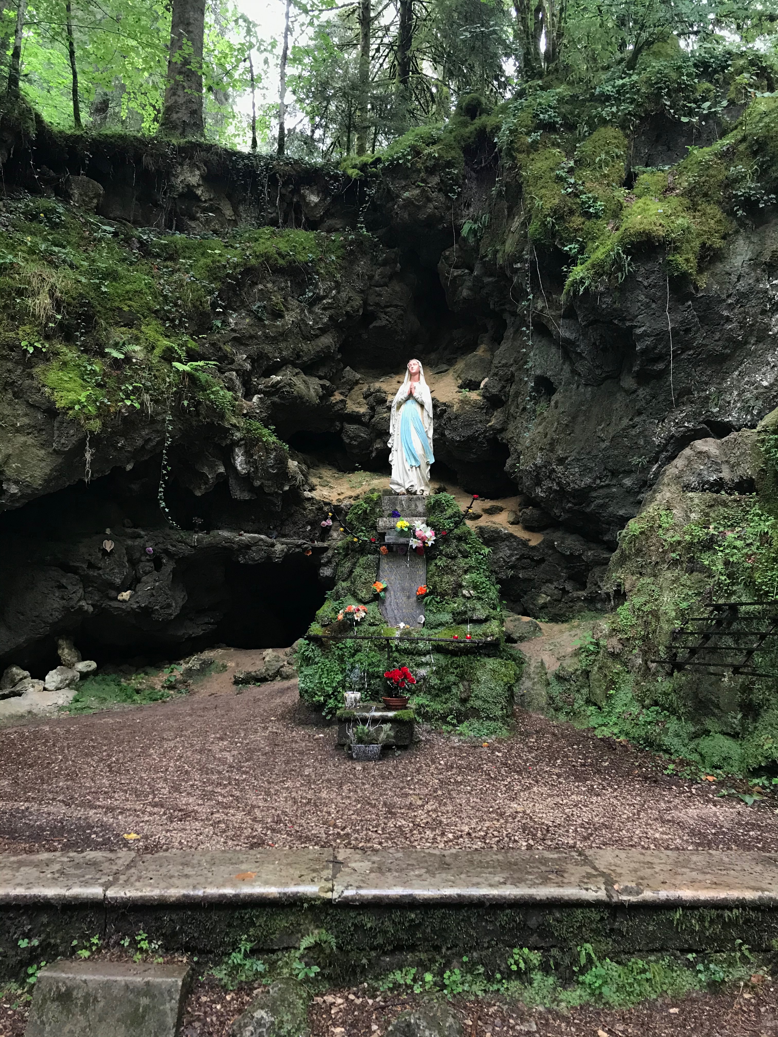 statue de la Vierge Marie devant un éboulement