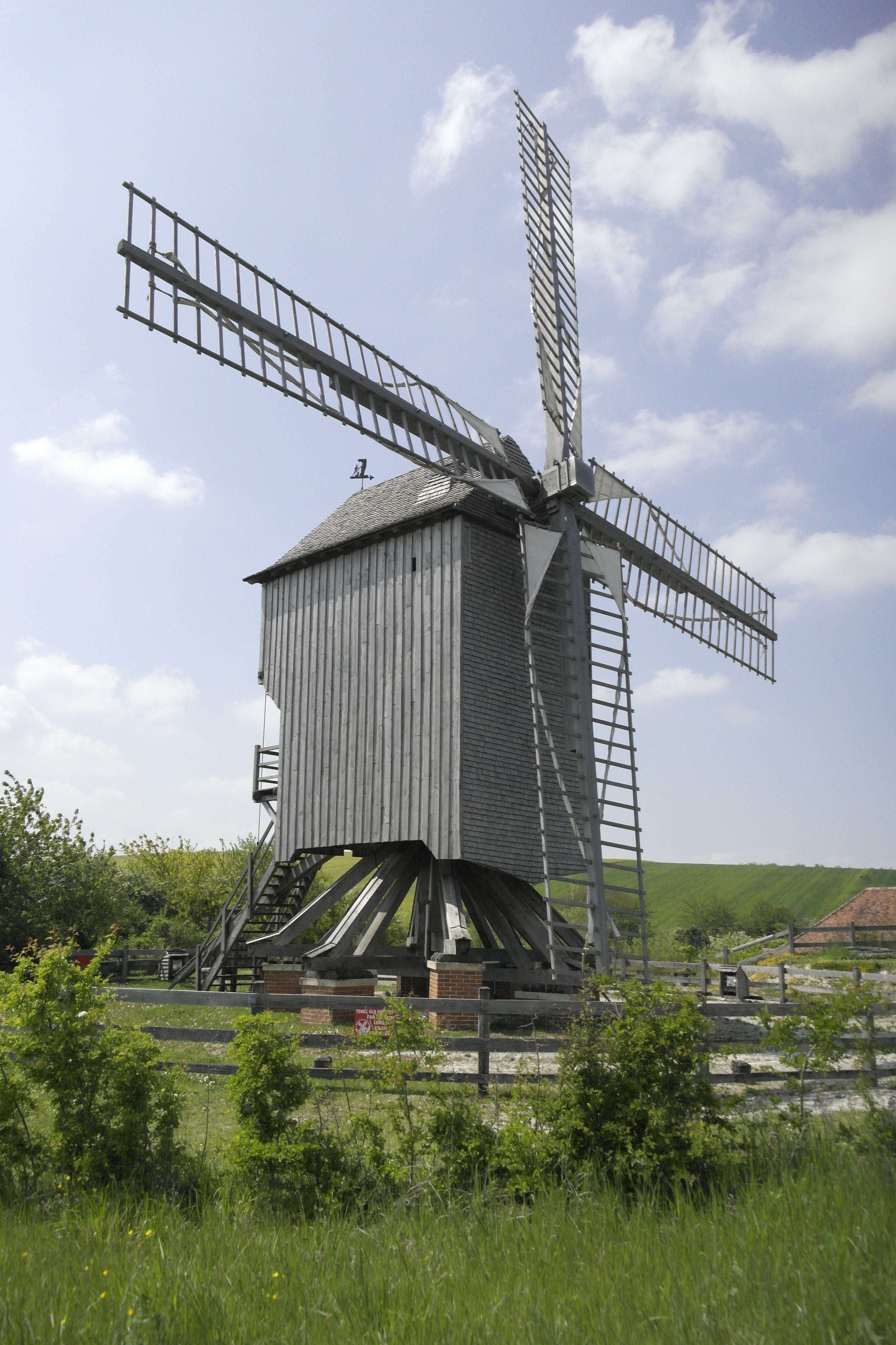 moulin à vent vu de côté, en bois, au milieu de l'herbe