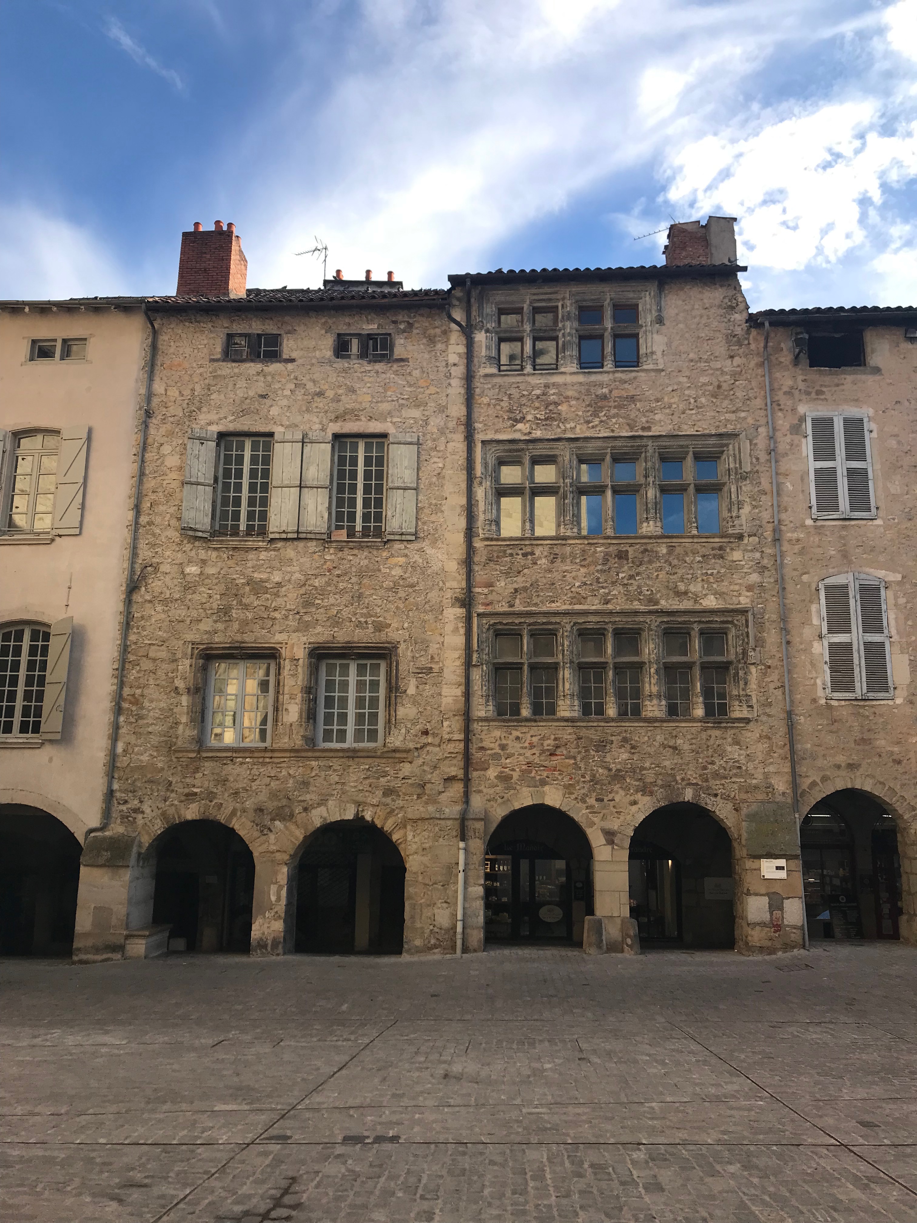 façades de maisons en pierre, fenêtres à croisées et meneaux, arcades au rez-de-chaussée