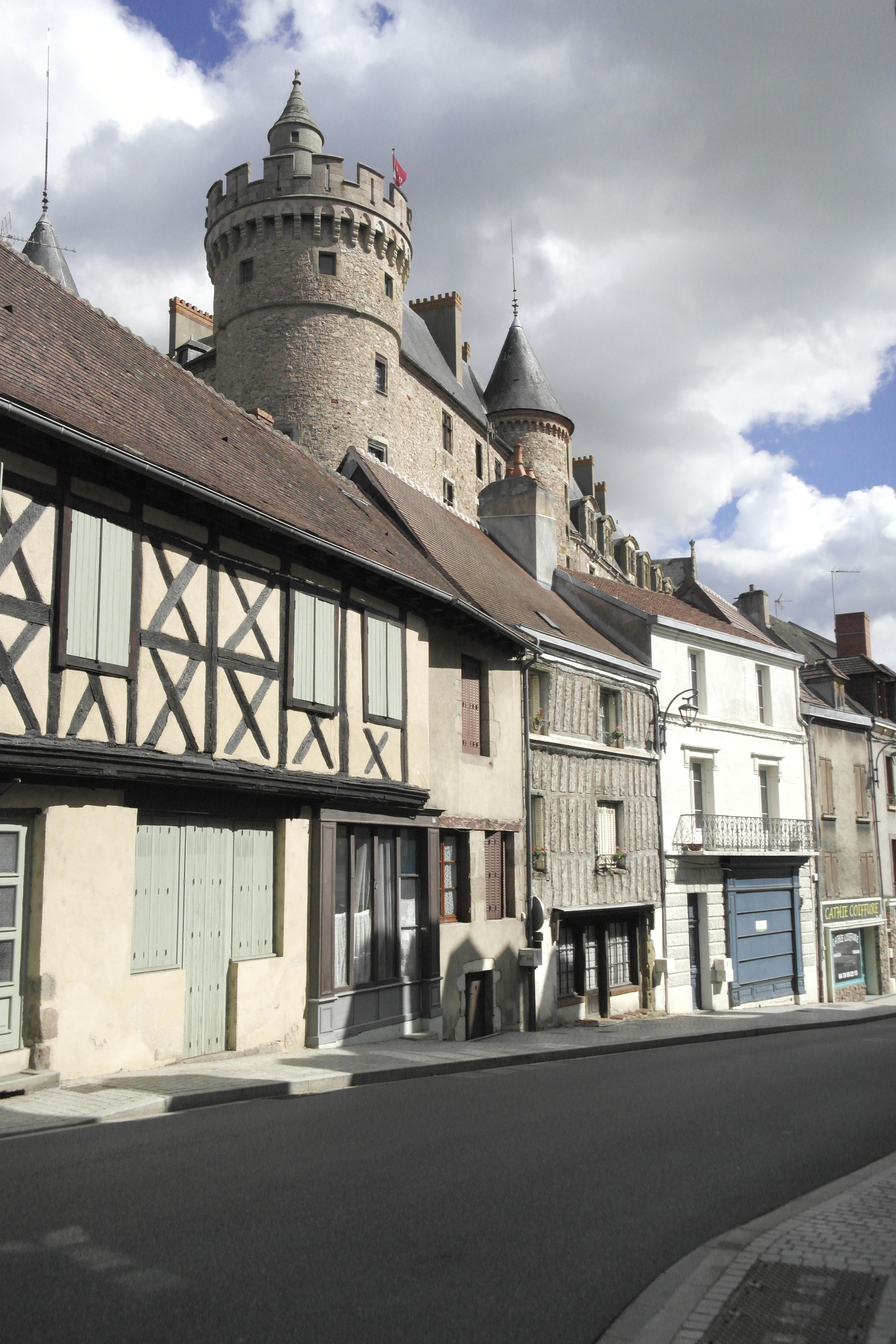 château en surplomb d'une rue aux maisons à colombages