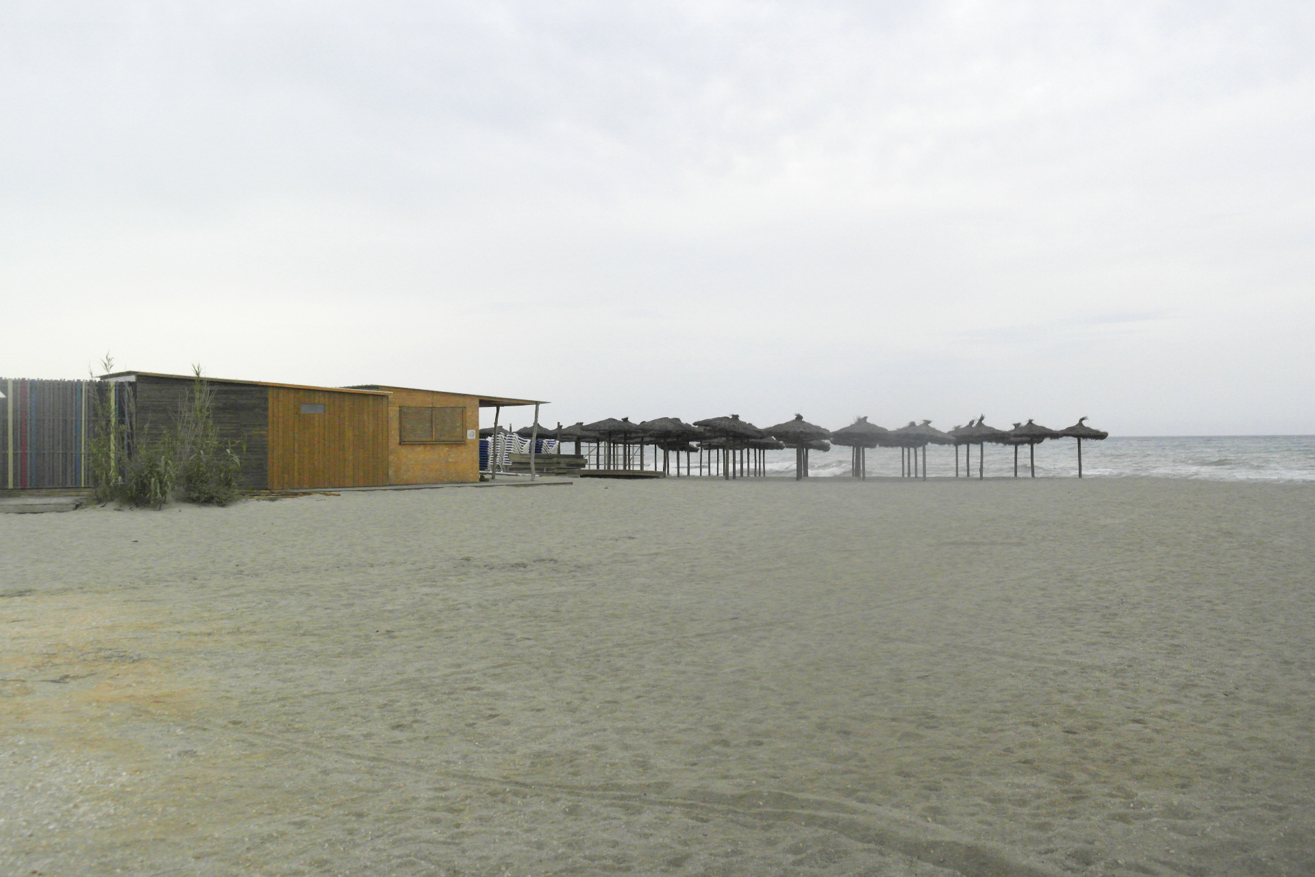 plage déserte, d'hiver, un cabanon et des parasols fixes