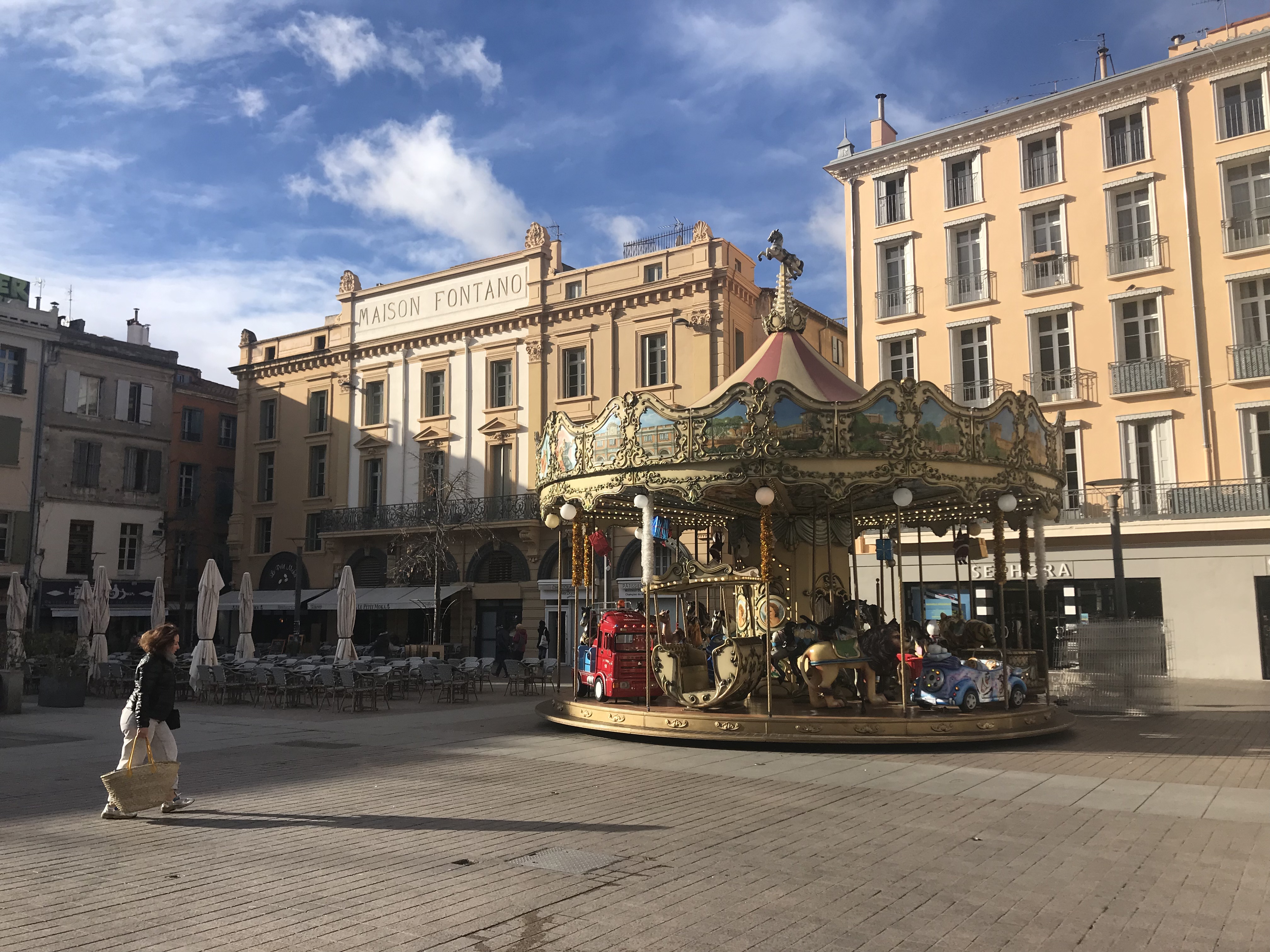 façades jaunes d'une place, carrousel en premier plan