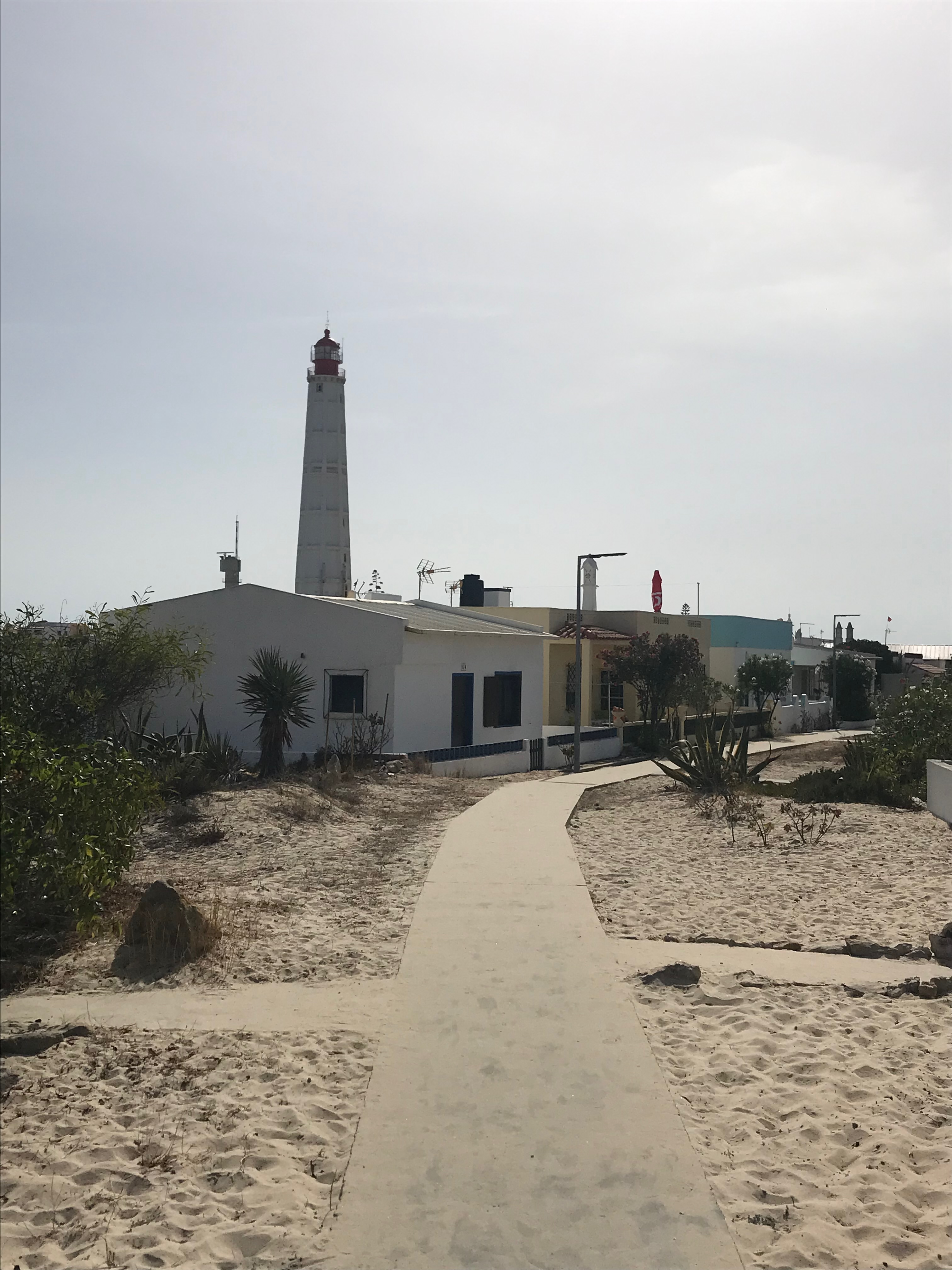 petites maisons dans le sable, phare au fond