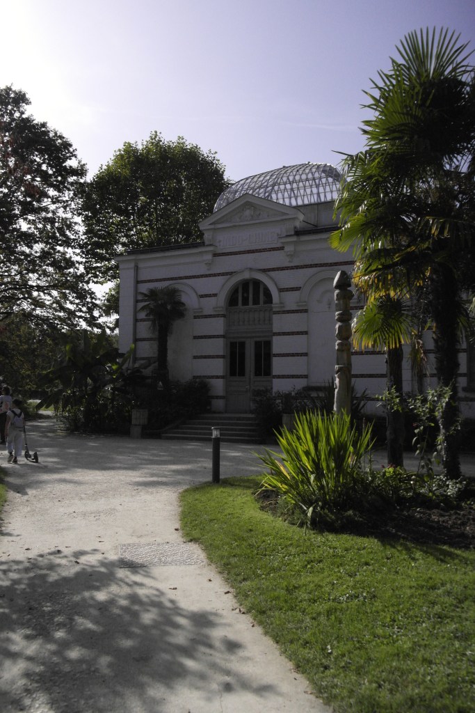 entrée d'un pavillon avec dome en verre, chemin et plantes tropicales