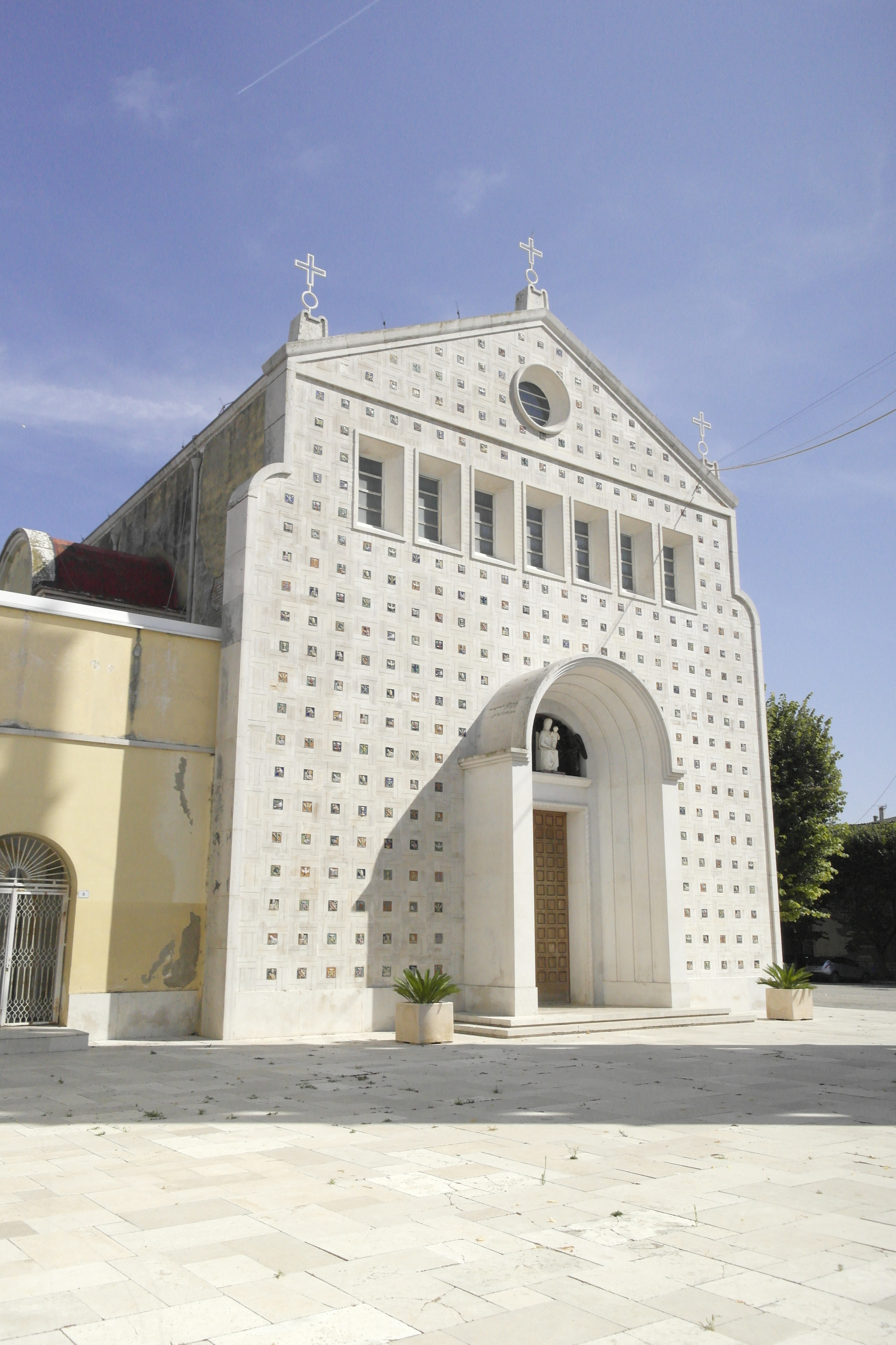 façade blanche d'église, ponctuée de petites céramiques