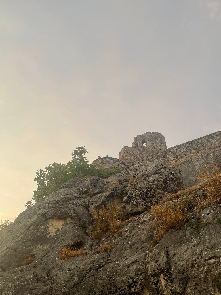 donjon sur éperon rocheux, ciel jaune