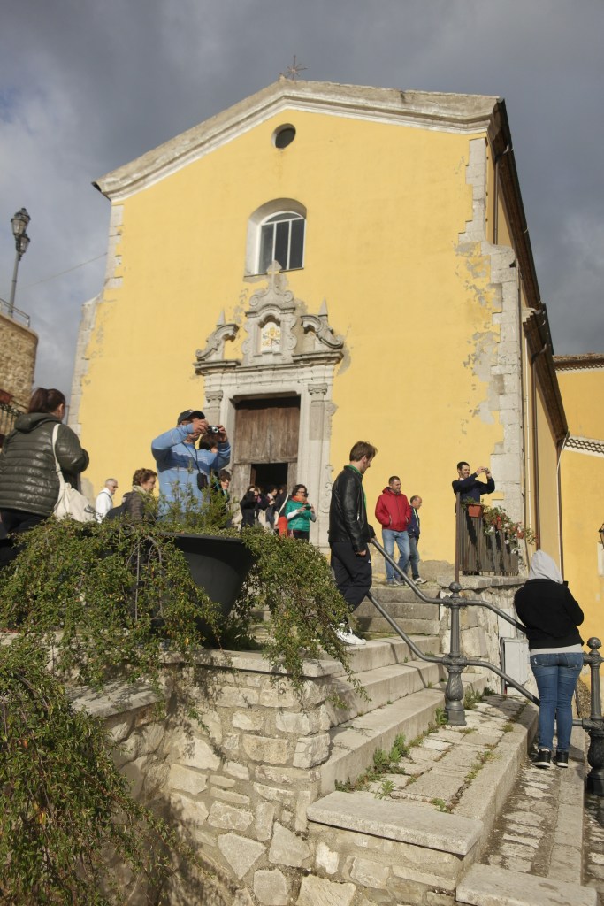 église jaune et groupe devant
